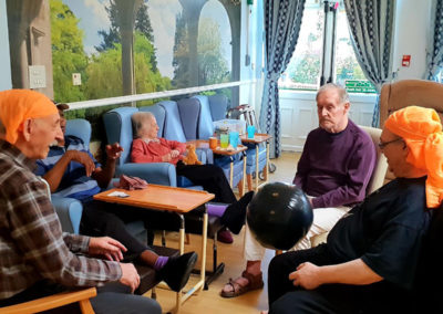 A group of seated residents batting a balloon between them