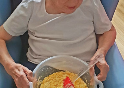 Female resident mixing different cake ingredients