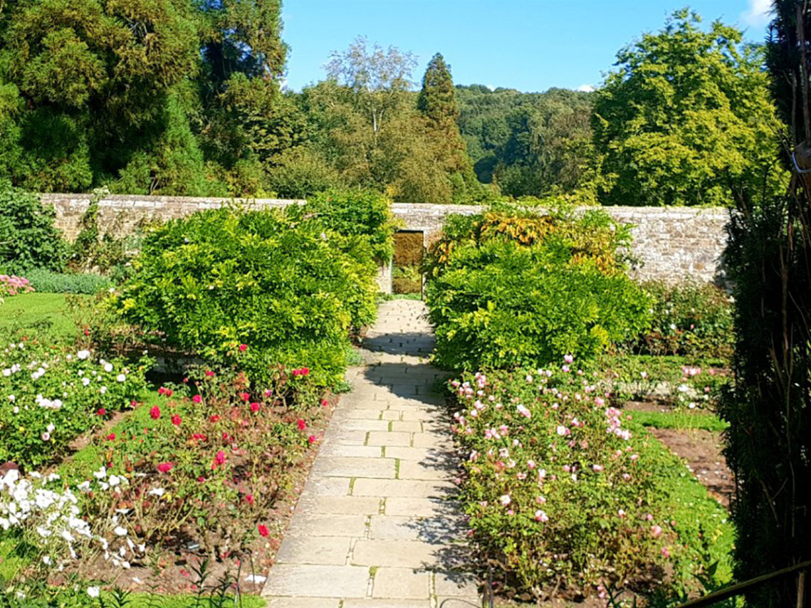 Beautiful gardens at Chartwell House with colourful flower beds and mature bushes and trees
