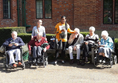 Five Lukestone Care Home residents with staff enjoying a drink outside Chartwell House