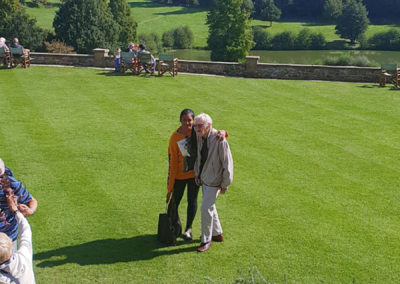 Lukestone resident and staff member walking across the landscaped gardens of Chartwell House