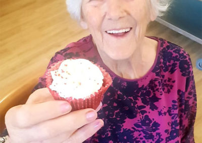 Female resident holding up a cupcake, smiling