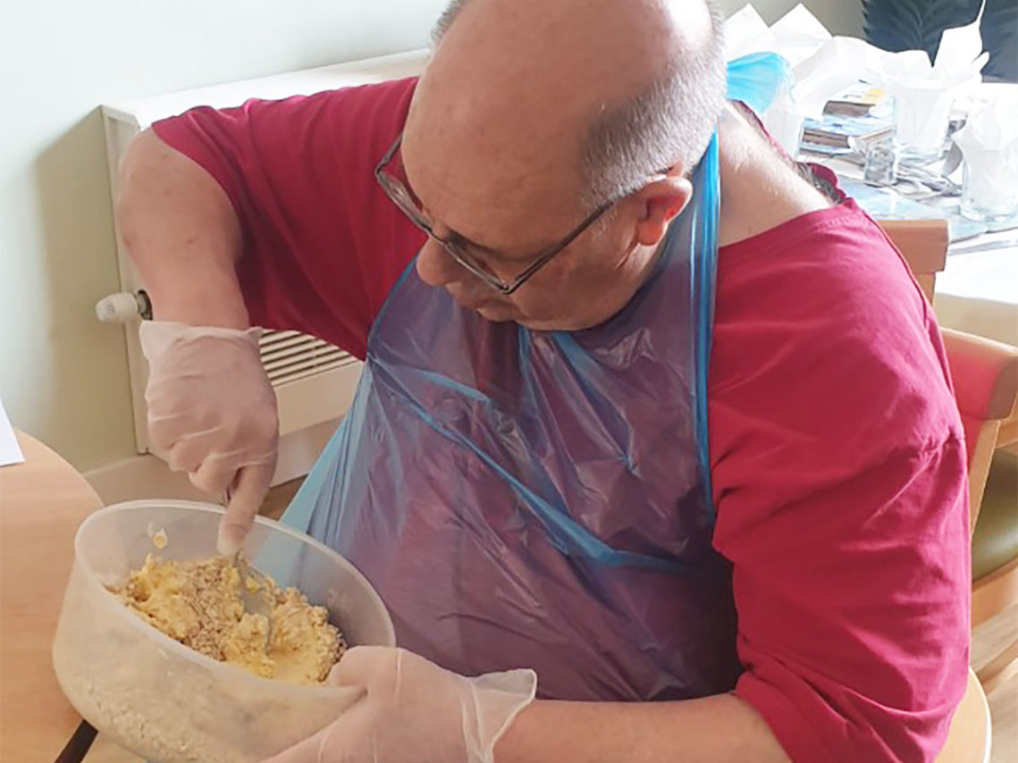 Male resident mixing scone ingredients