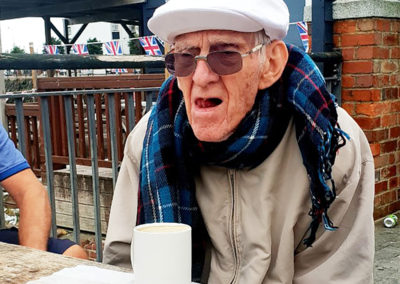 A gentleman resident sitting outside with a cup of tea during a trip to Folkestone