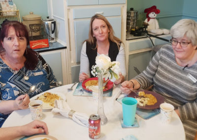 Staff at Lukestone Care Home sat around a table enjoying lunch dishes from around the globe