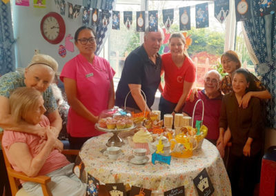 Residents and staff around a tea party table