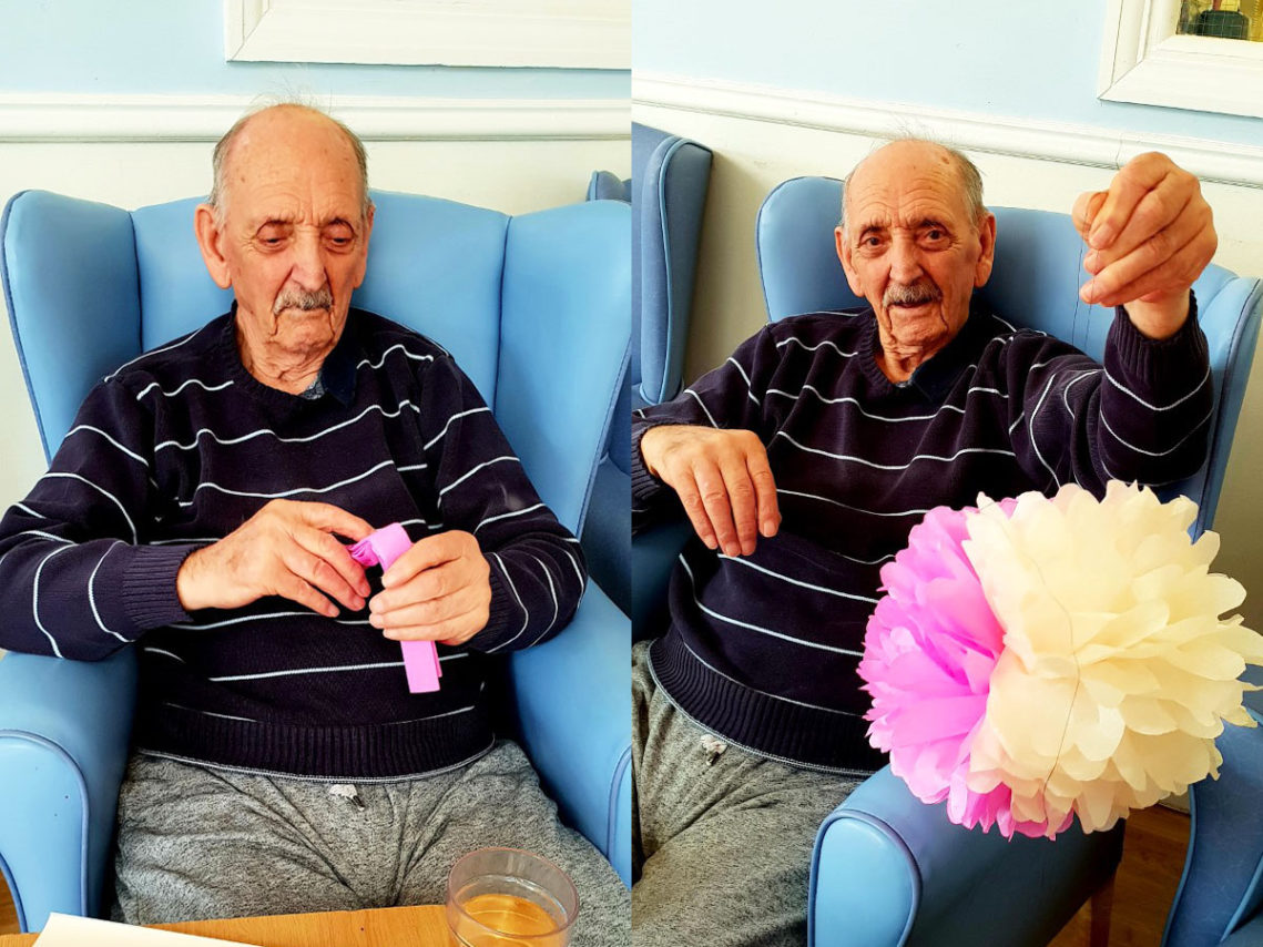 Male resident making a tissue. paper pom pom at Lulworth House Residential Care Home