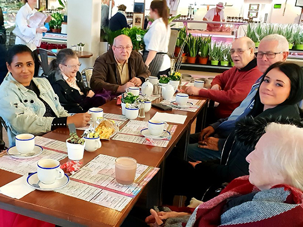 Staff and residents around a table enjoying a coffee at Polhill Garden Centre