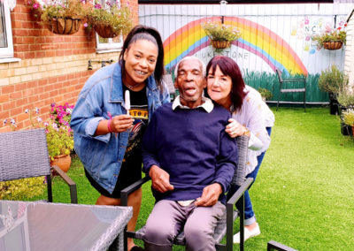 Three people smiling for the camera whilst enjoying the garden at Lukestone Care Home