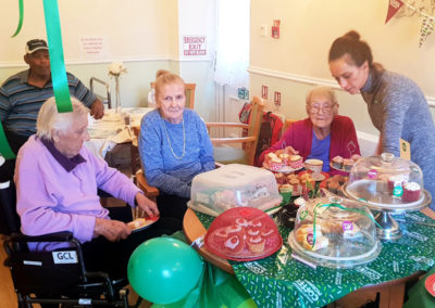 Lukestone staff member serving cakes and tea to residents during their Macmillan coffee morning
