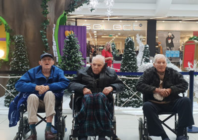 Lukestone Care Home male residents sitting next to a festive display at a shopping centre