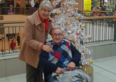 Lukestone Care Home male resident, with his wife next to a festive tree at a shopping centre