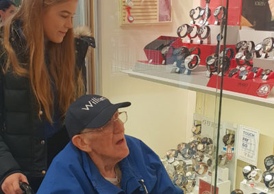 Lukestone Care Home male resident looking at watches in a shop window at a shopping centre
