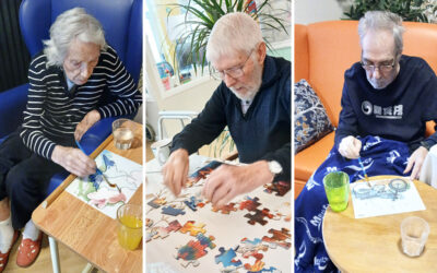 Residents at Lukestone Care Home participating in aqua painting and puzzle activities during a group session.